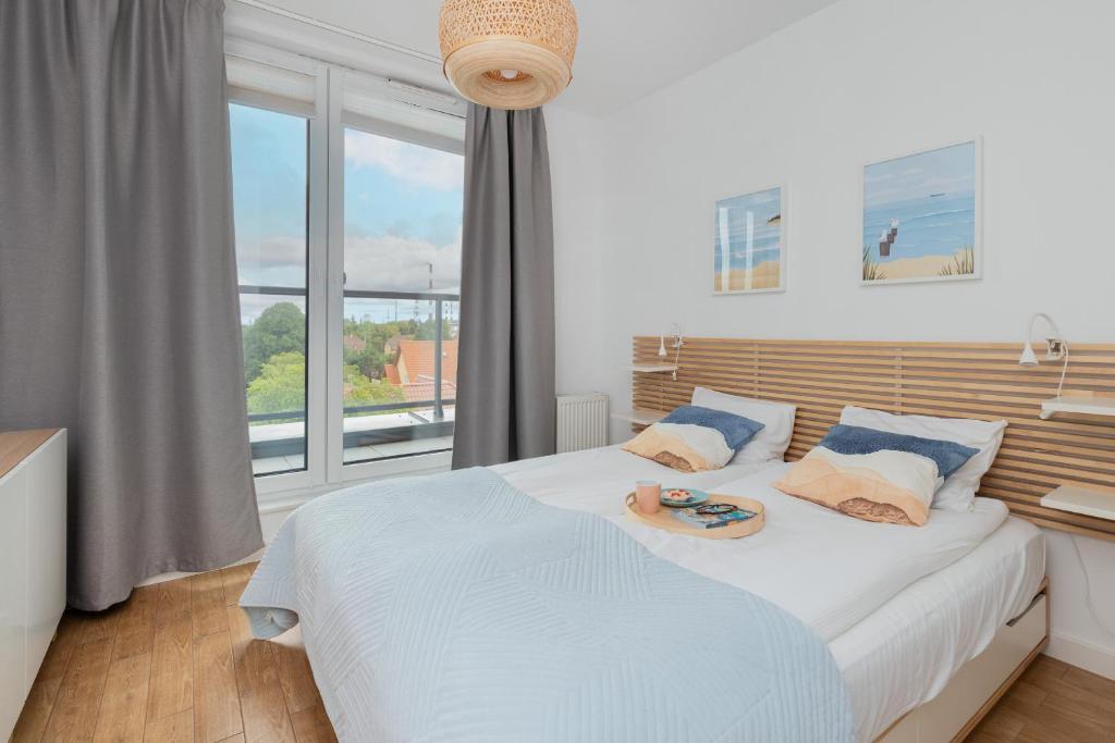 a bedroom with a bed and a large window at Bright & Trendy Gdańsk Apartment with Balcony by Renters in Gdańsk