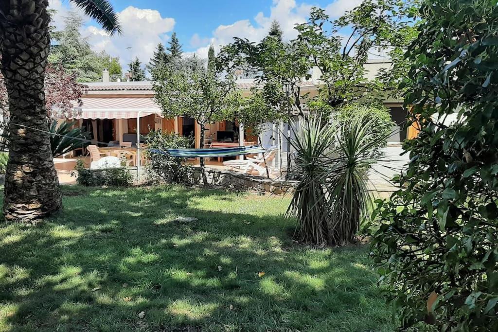 a yard with a house with a pool and trees at Villa roverella in Cassano delle Murge