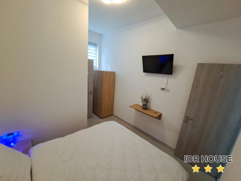1 dormitorio con 1 cama y TV en la pared en IDR HOUSE, en Buzău