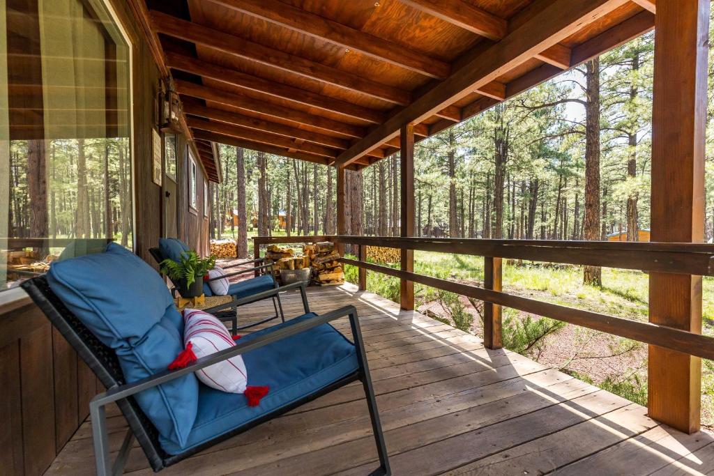 a rocking chair on a porch of a cabin at Autumn Mountain Vacations - Book Now! Rogue Bear Cabin in Williams