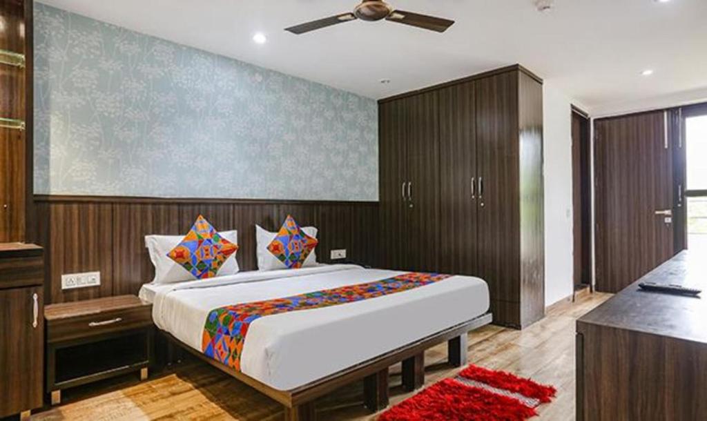 a bedroom with a large bed with a ceiling fan at FabExpress RG Stay in New Delhi