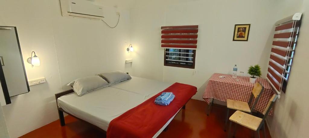 Kleines Zimmer mit einem Bett und einem Tisch in der Unterkunft Coastal Cabana Marari in Mararikulam