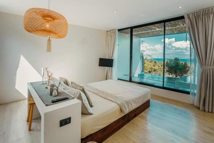 1 dormitorio con cama y ventana grande en Myth Koh Larn resort bar and bistro en Ko Larn