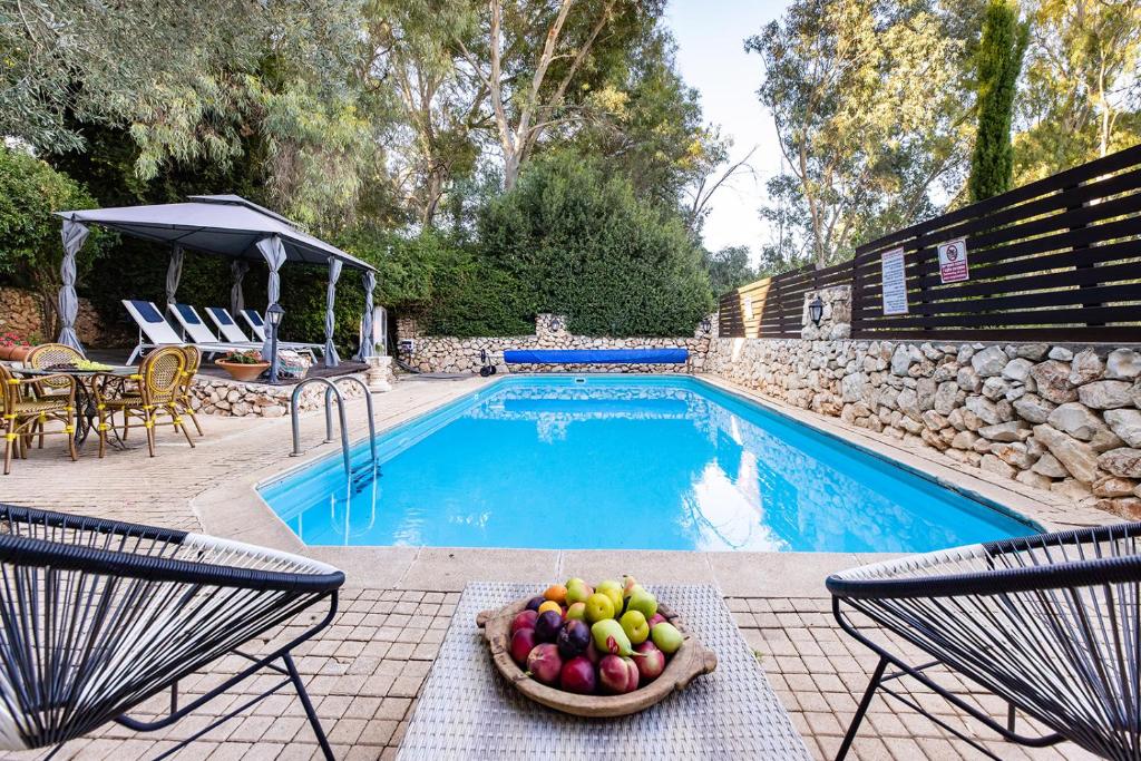 un bol de fruta sentado junto a una piscina en THE HOUSE ROSH PINA - 3BRM WITH POOl, en Rosh Pina