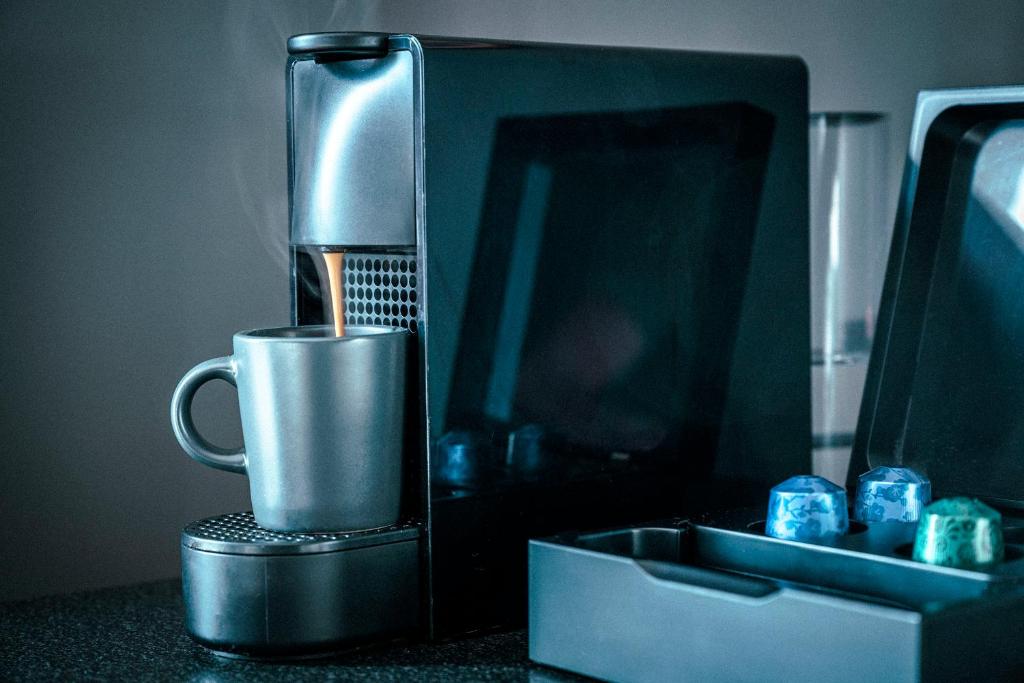 a coffee maker sitting on a counter with a cup at Hotel Filip in Oslo