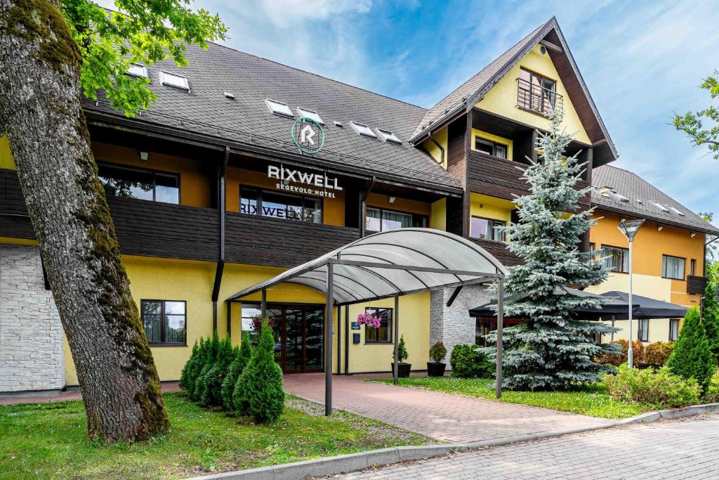 a hotel building with a tree in front of it at Rixwell Segevold Hotel in Sigulda