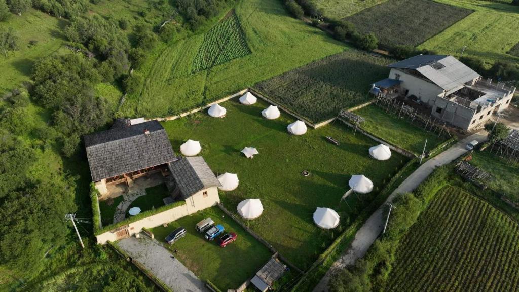 an aerial view of a house with hay bales at Shangri -la Liotard Farm Fix Camp in Shangri-La