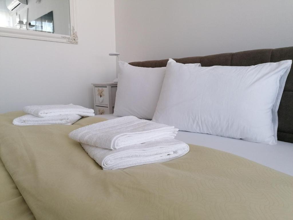 2 toallas están apiladas en la parte superior de una cama en Apartman Enio en Vukovar