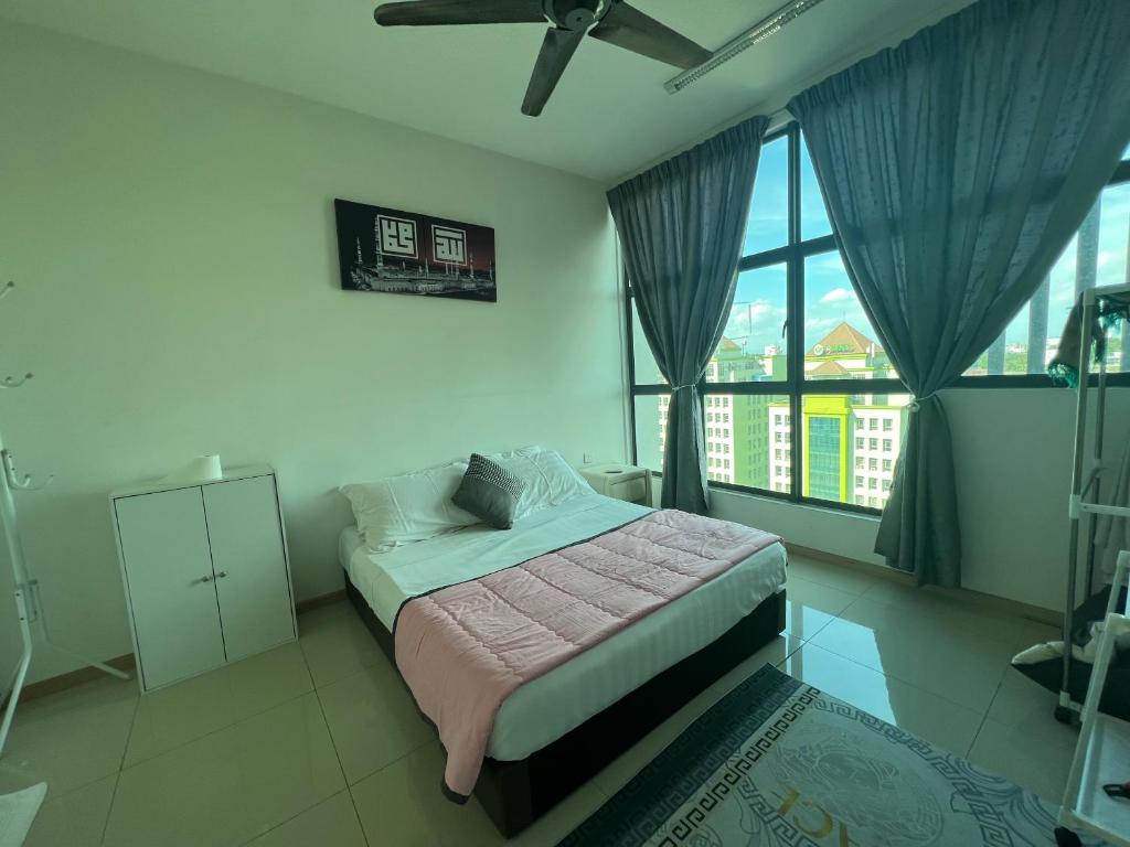 ein Schlafzimmer mit einem Bett und einem großen Fenster in der Unterkunft Vista Alam in Shah Alam