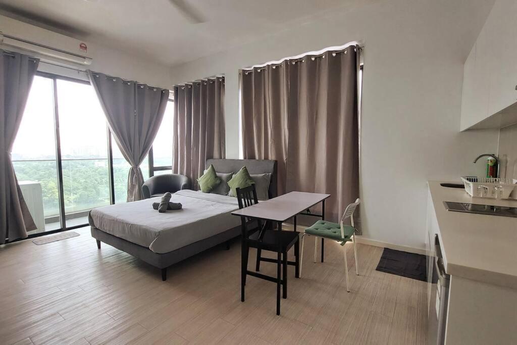 a bedroom with a bed and a table and a kitchen at The Grand#11, Free Parking,2pax in Petaling Jaya