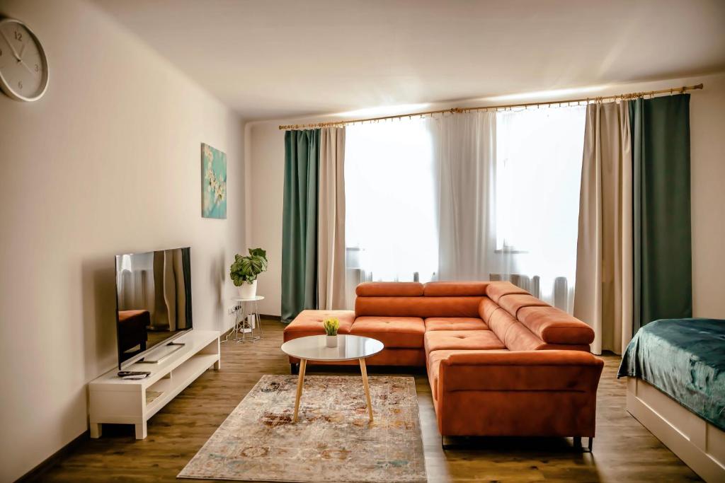 ein Wohnzimmer mit einem Sofa und einem TV in der Unterkunft Luxusní apartmán na Velkém náměstí in Hradec Králové