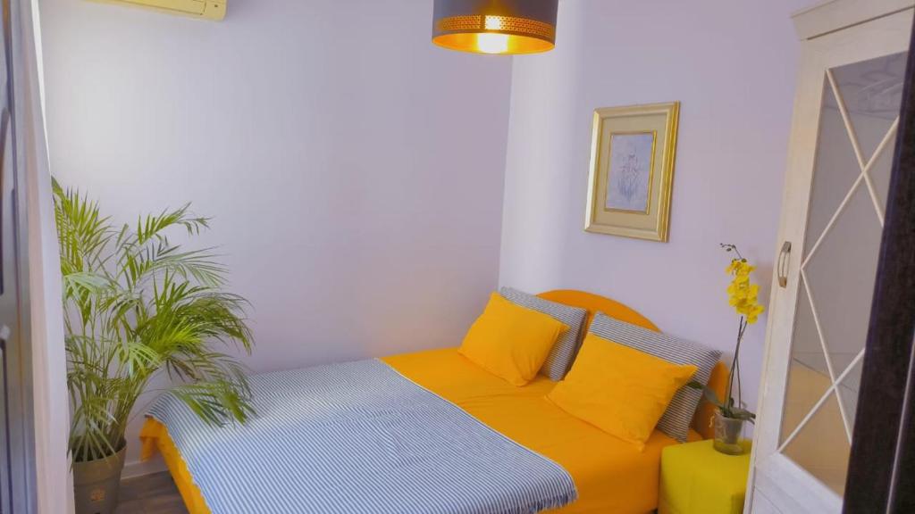 um quarto com uma cama com almofadas amarelas em Apartment Dmitr Petrovac em Petrovac na Moru