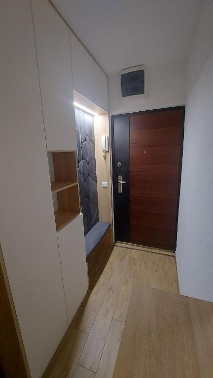 pasillo con puerta y suelo de madera en Studio apartman Iskra, self check IN-OUT en Županja