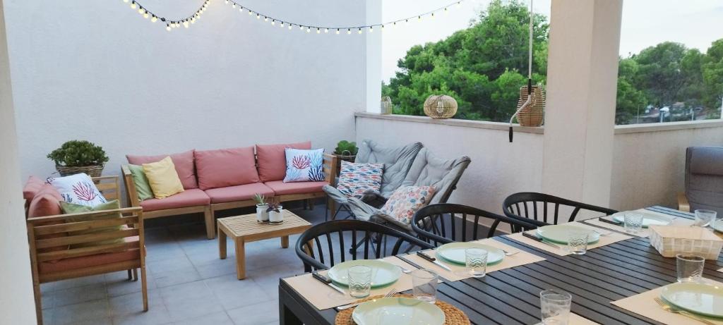 a patio with tables and chairs and a couch at Casa Calafat in Calafat