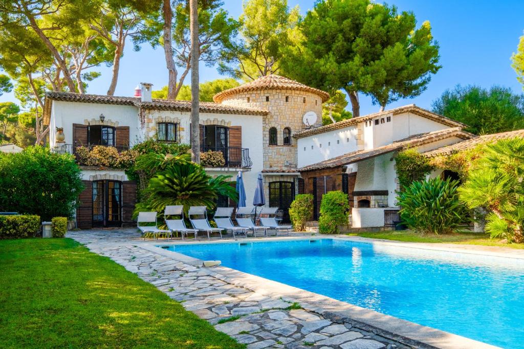 un domaine avec une piscine en face d'une maison dans l'établissement Villa Provenzale Clos de Minerve, à Juan-les-Pins