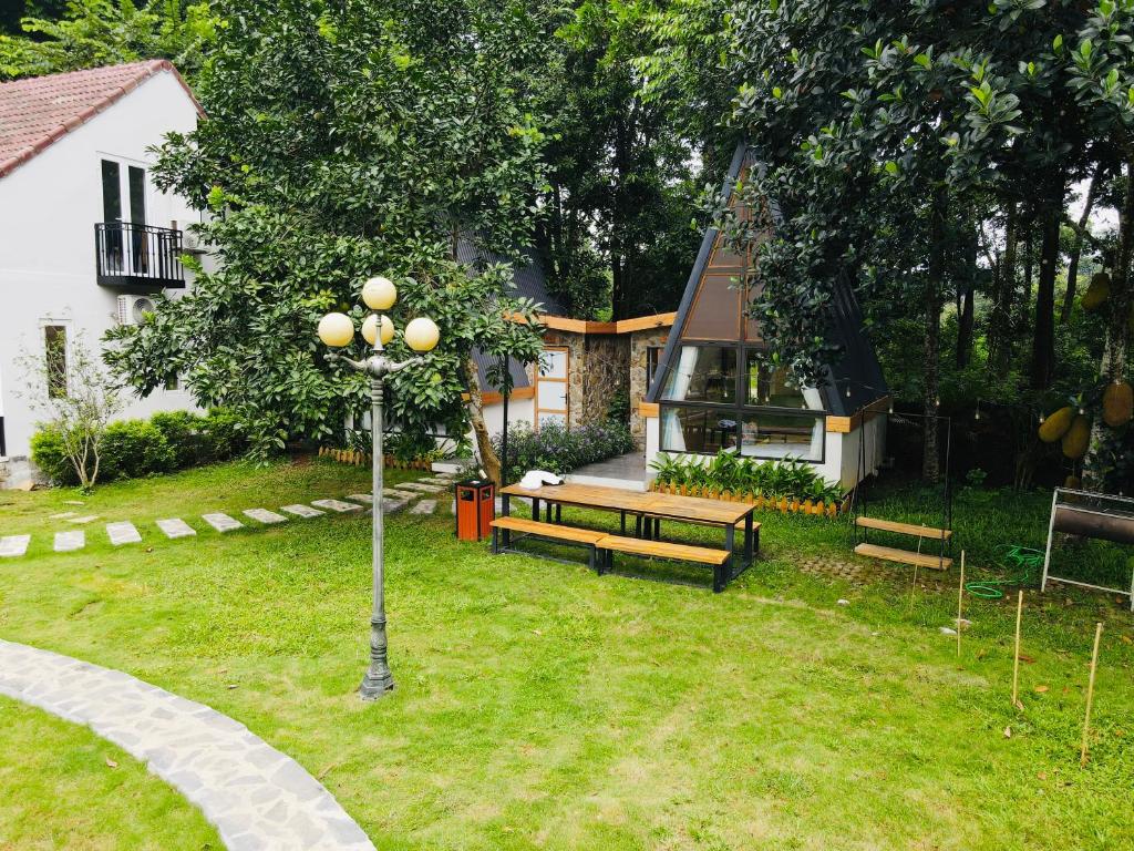 a park with two benches in a yard with a house at Interconnection Ba Vì Venuestay in Hanoi