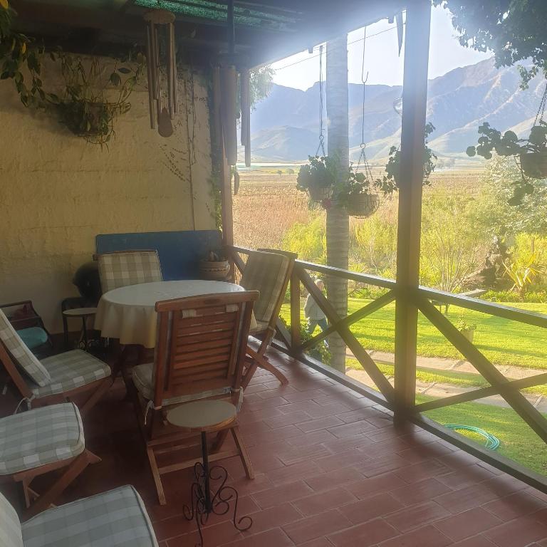 porche con mesa, sillas y vistas a un campo en IRMAS FARMSTAY AT NUYVALLEY GUESTFARM, en Nuy