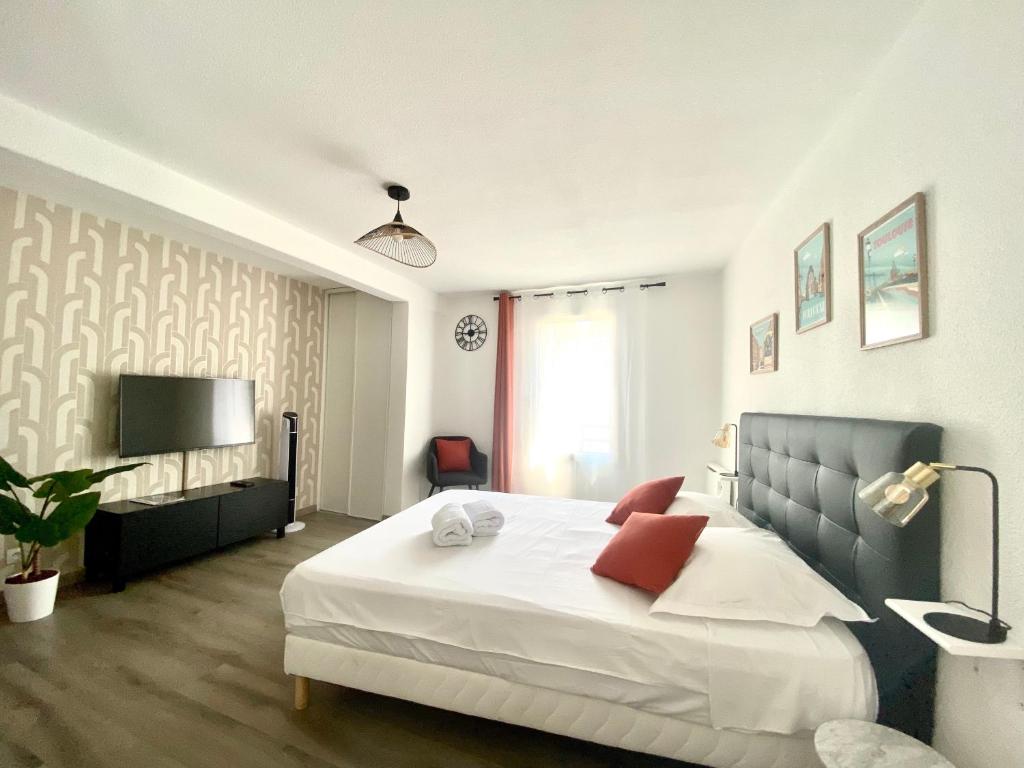 une chambre avec un grand lit et une télévision dans l'établissement Le Chaleureux - Studio proche du Jardin Compans, à Toulouse