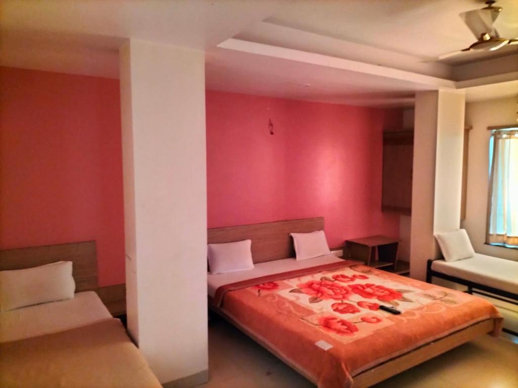 Postel nebo postele na pokoji v ubytování HOTEL SAI SURYA