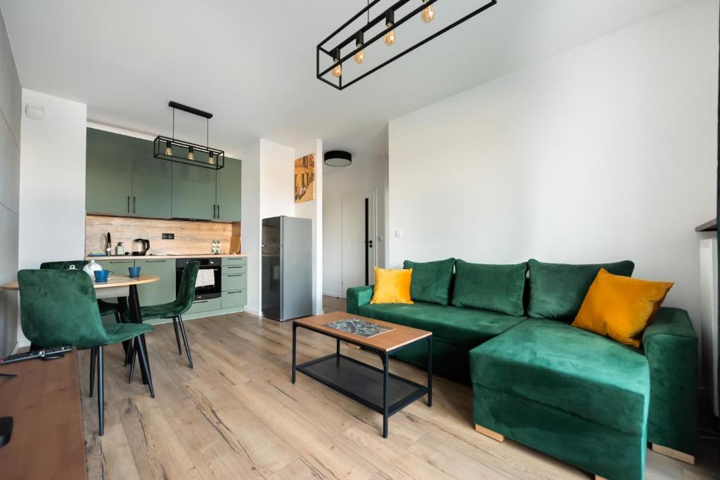 un soggiorno con divano verde e tavolo di Nova Sfera Green Apartment a Varsavia