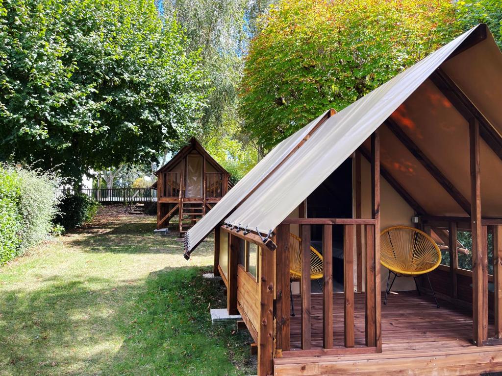 a group of wooden huts in a yard at Camping Canal de Berry in Saint-Amand-Montrond