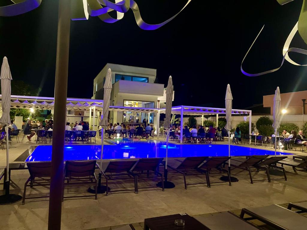 een zwembad 's nachts met tafels en stoelen bij B&B Casanova in Minervino di Lecce