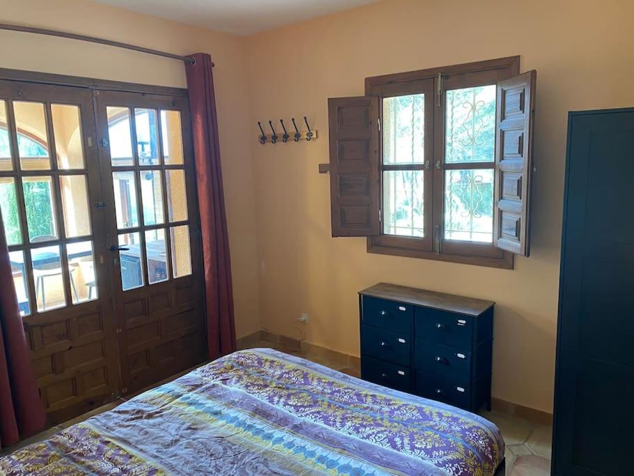 Casa del jabali - Tiny house في Tivissa: غرفة نوم بسرير وخزانة ونوافذ