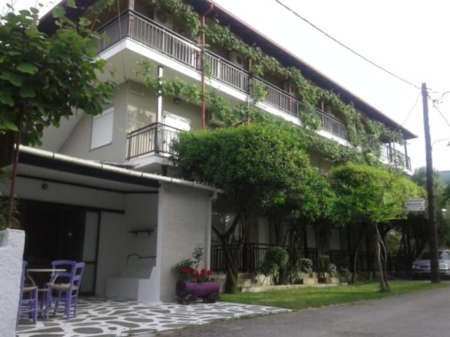 a building with plants growing on the side of it at Helena Apartments in Paralia Panteleimonos