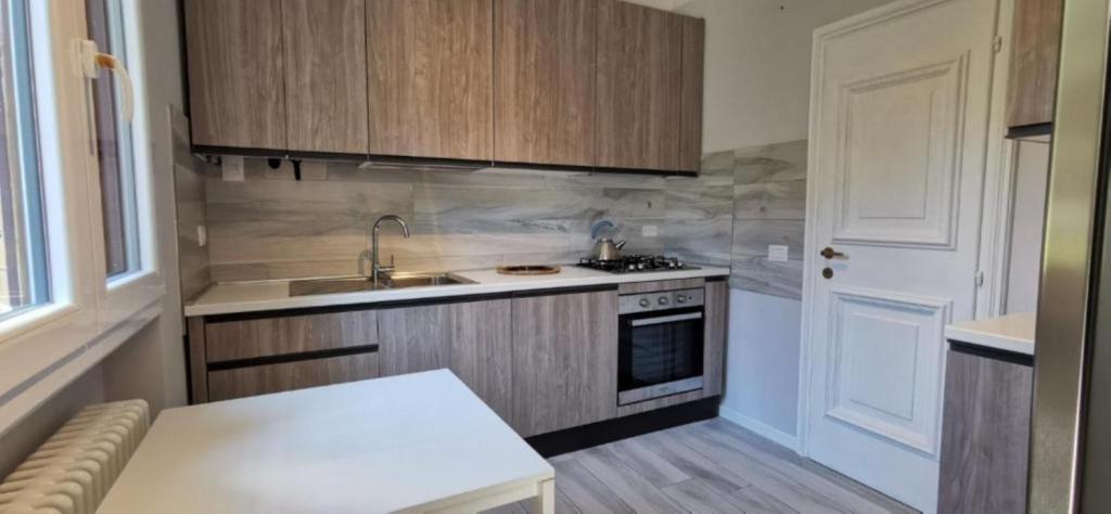 una piccola cucina con lavandino e piano cottura di grande appartamento zona viale ceccarini con giardino a Riccione