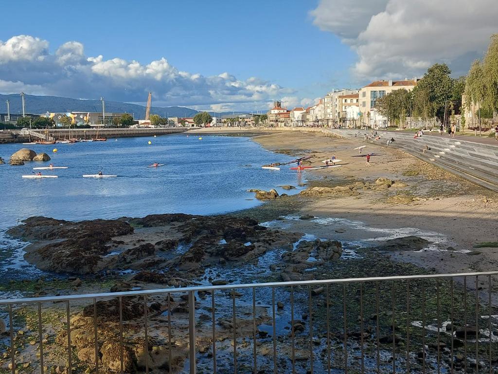 ビーゴにあるPiso en Vigo con vistas a la ríaの水中の人々と共に海岸を望む