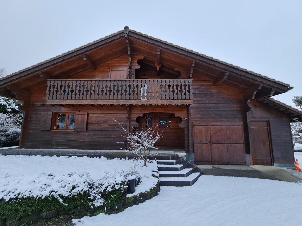 a log cabin with a balcony and snow on the ground at Chalet Van Gogh in Morillon