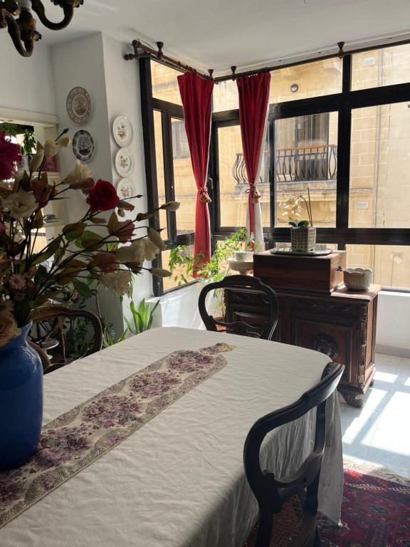 une chambre avec deux tables et une table avec un vase dans l'établissement My apartment to rent one room, à Sliema