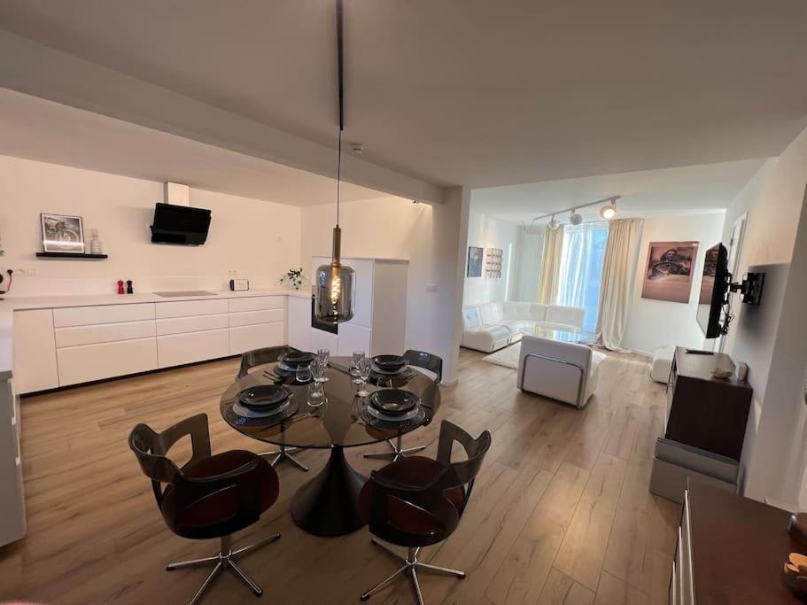 ein Wohnzimmer mit einem Tisch und einigen Stühlen in der Unterkunft Charmant appartement au look design in Mons