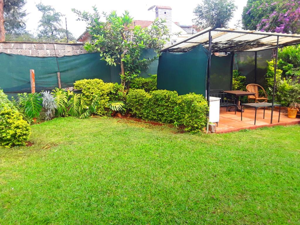 a garden with a tent and a table and chairs at New Kitisuru A in Nairobi