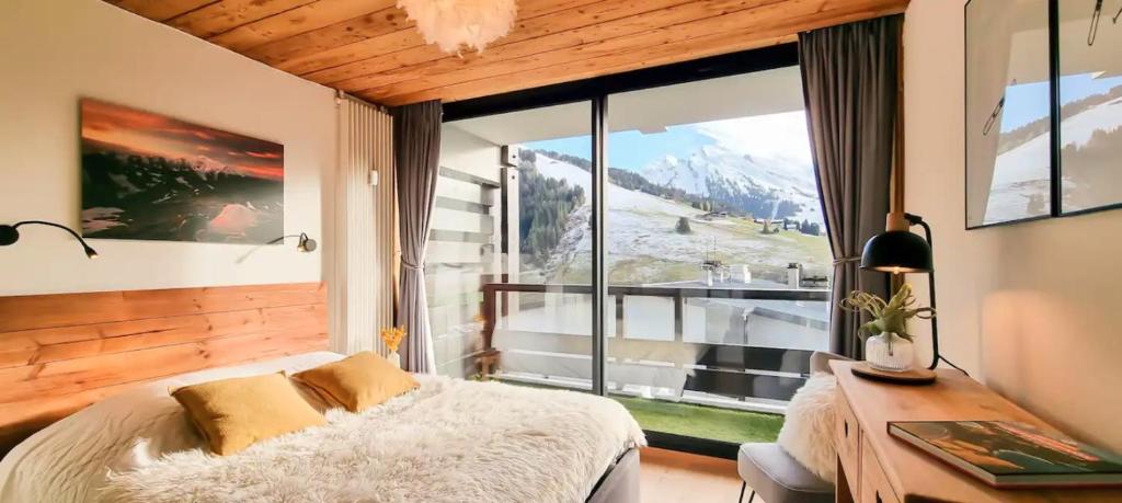 une chambre avec un lit et une grande fenêtre dans l'établissement The White Bear - Appartement Spacieux et Confortable, à La Clusaz