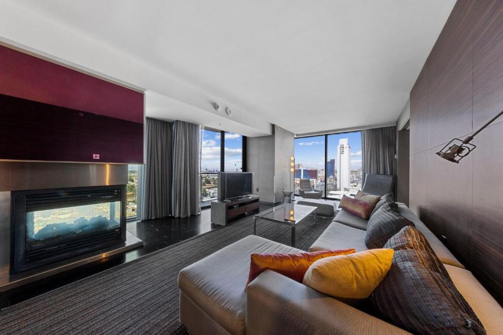 a living room with a couch and a fireplace at Modern Luxury 17 Floor Panoramic Huge Corner Suite in Las Vegas