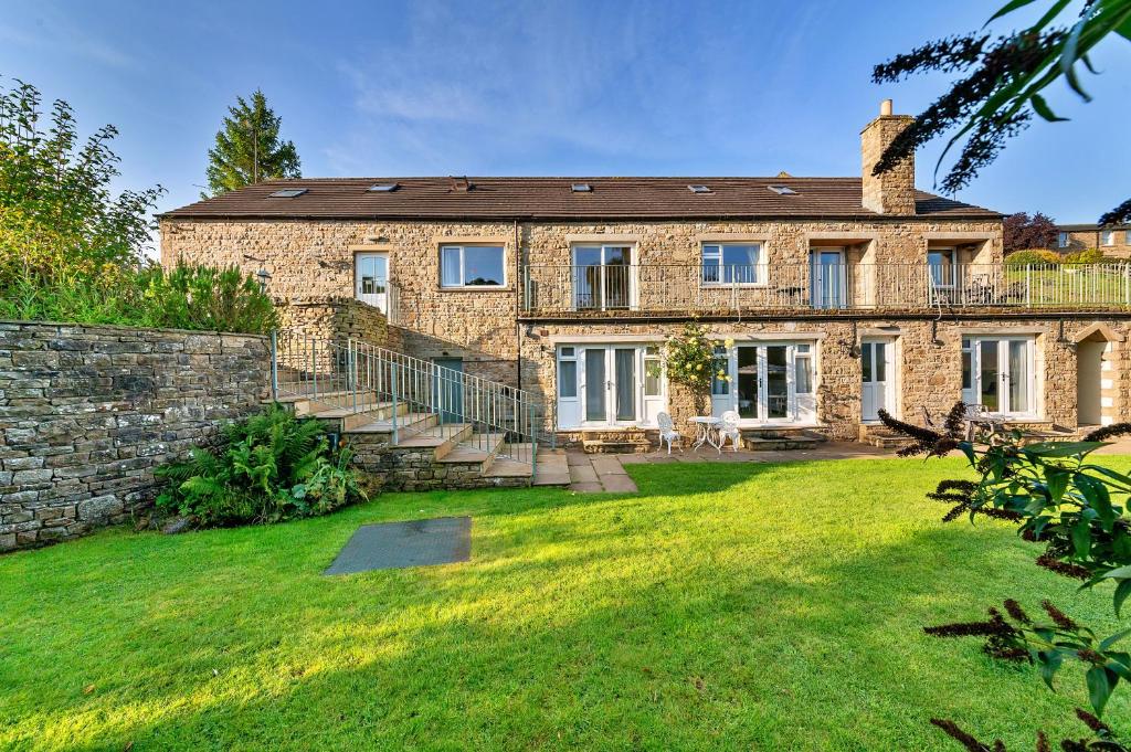 a large brick house with a grass yard at Finest Retreats - Loxley House in Hawes
