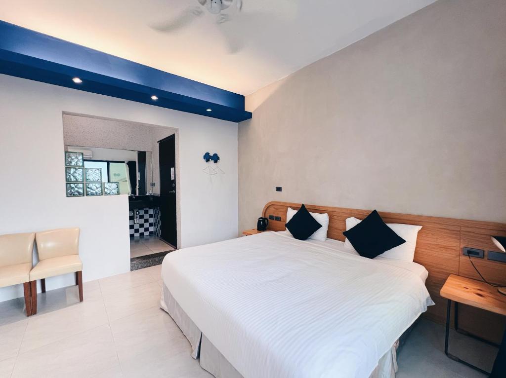 a bedroom with a large white bed and a desk at Qixingtan Xinghai B&amp;B in Dahan