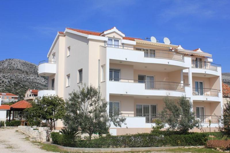 een groot wit gebouw met bomen ervoor bij Holiday apartment in Seget Vranjica with sea view, terrace, WiFi, washing machine 5181-2 in Seget Vranjica