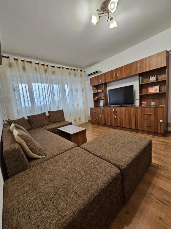 a living room with a couch and a flat screen tv at Cosy apartment close to City Center with parking lot in Bucharest