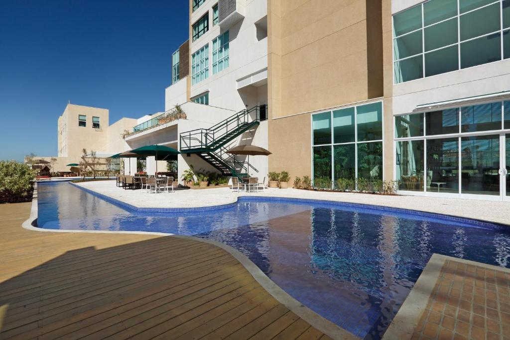 a swimming pool in front of a building at Vitória Hotel Convention Paulínia in Paulínia