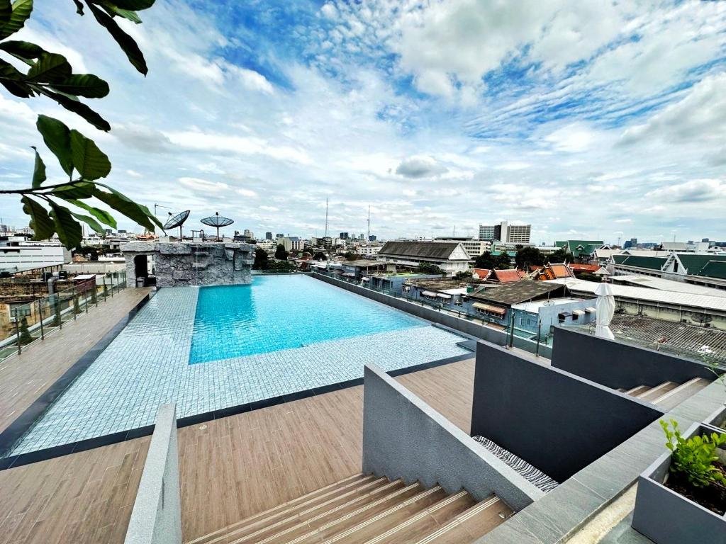 A rooftop pool with steps down to a tiled deck and wide city views.