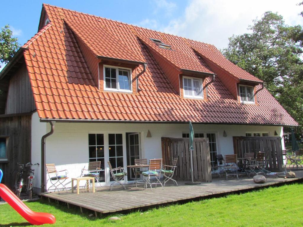 une maison avec un toit orange et une terrasse dans l'établissement Hus-Hiddensee-Eckhaus-A, à Vitte