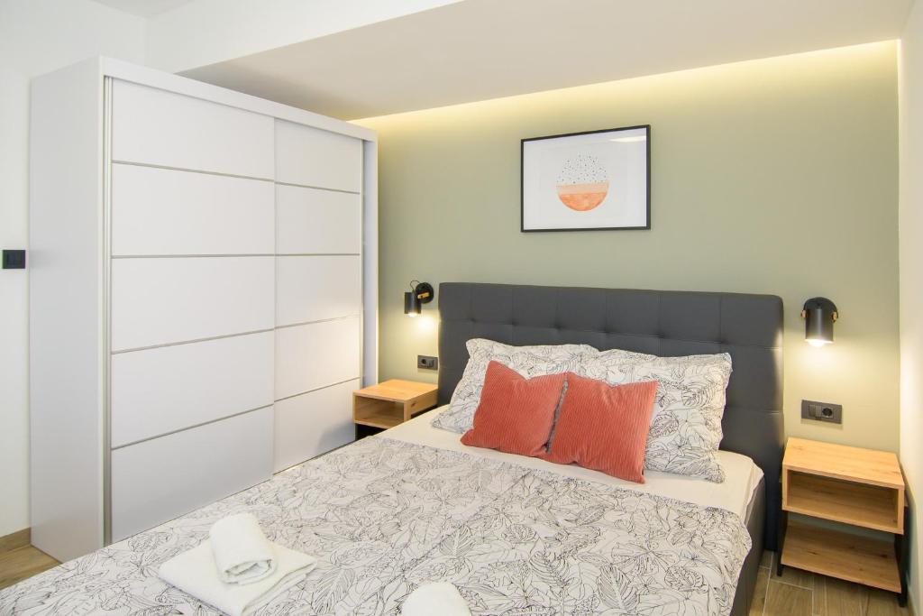 a bedroom with a large bed with orange pillows at Apartments & Rooms Darrer in Poreč