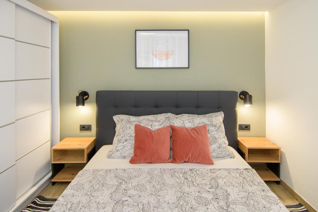 a bedroom with a bed with two orange pillows at Apartments & Rooms Darrer in Poreč