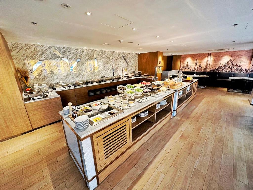 A bright breakfast buffet with a central island and hot-food stations.