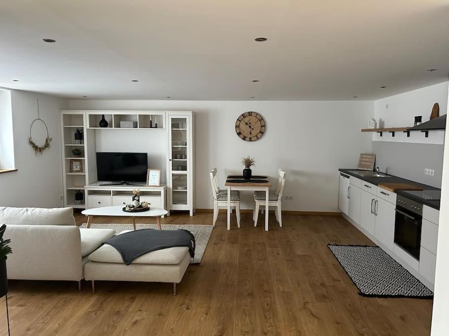 uma sala de estar com um sofá branco e uma mesa em „Main“ Zuhause em Kleinheubach