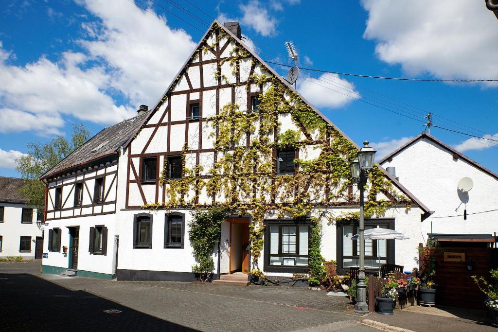 a large white building with ivy on it at Mählich Haus in Manderscheid