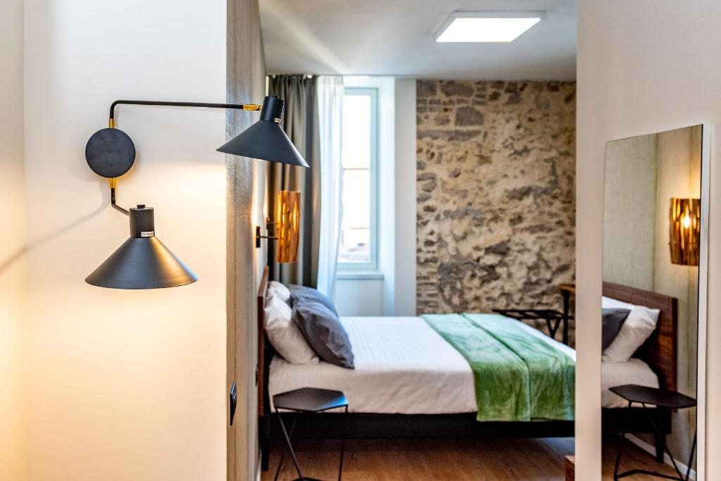 a bedroom with a bed and a lamp and a mirror at The Place - Only Self Check-in - No Reception in Trento