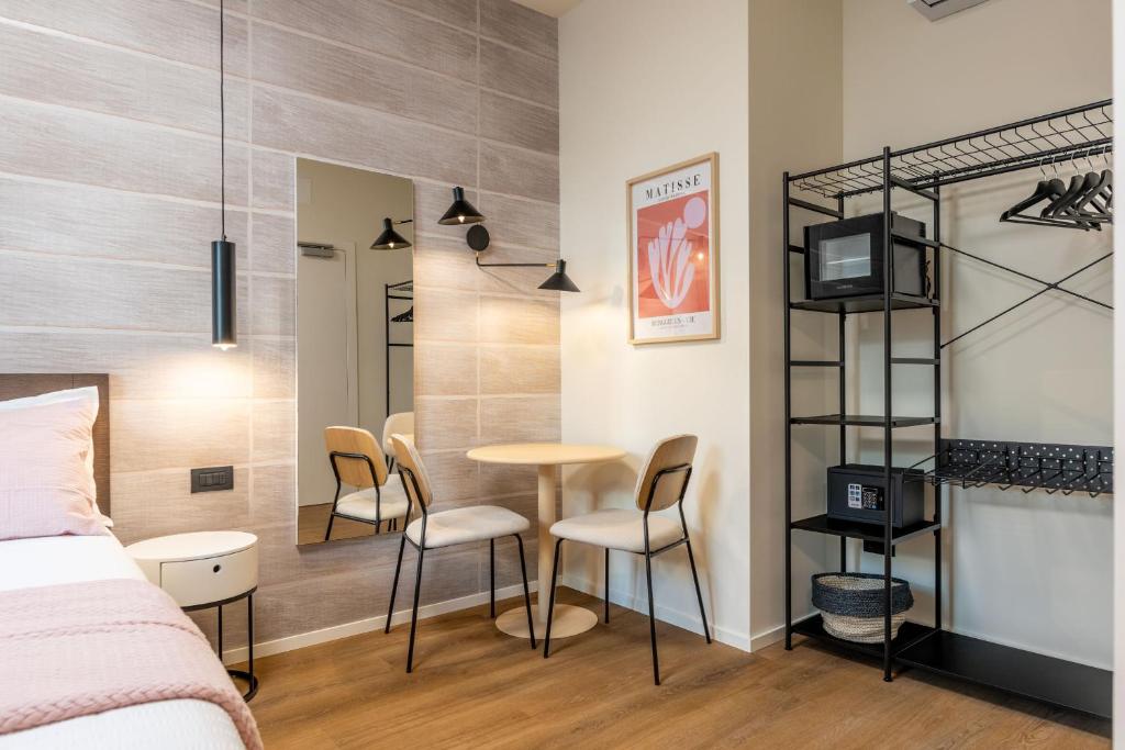 a bedroom with a bed and a table and chairs at The Place - Only Self Check-in - No Reception in Trento